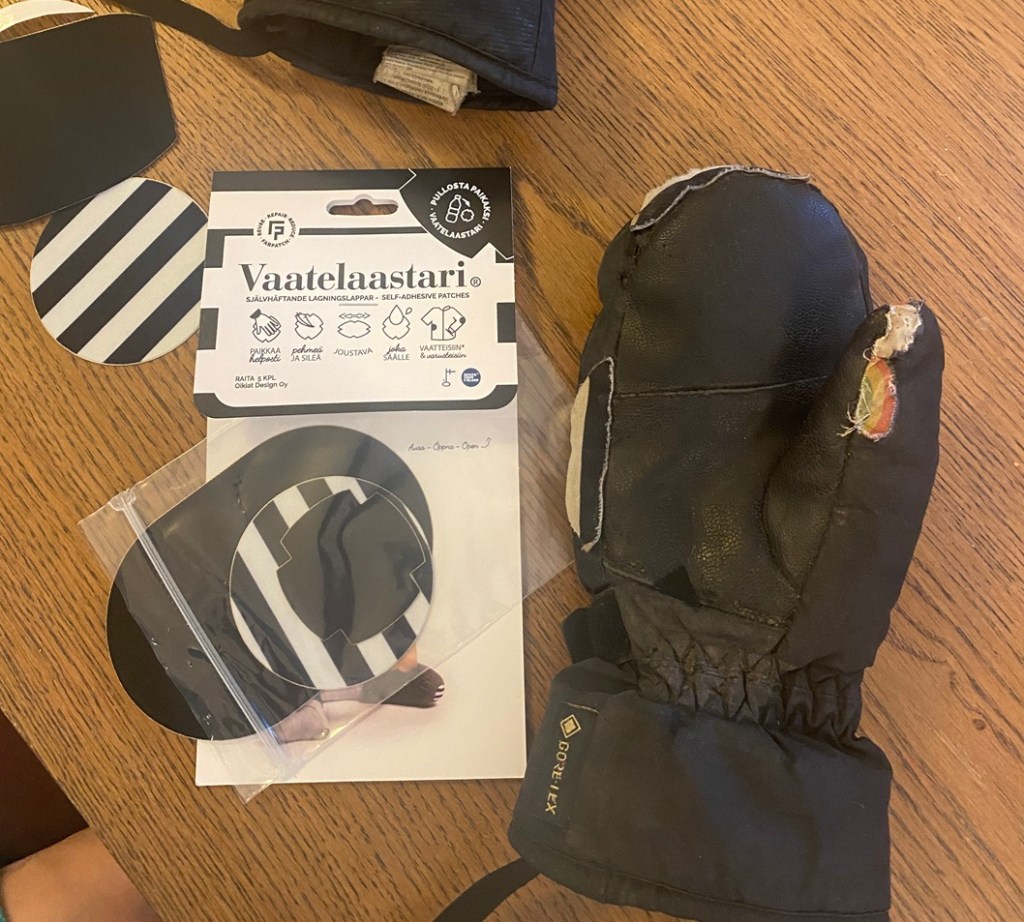 kuvassa mustat ja mustavalkoiset raidalliset liimattavat vaatelaastarit sekä yksi niillä korjattu paksu talvirukkanen