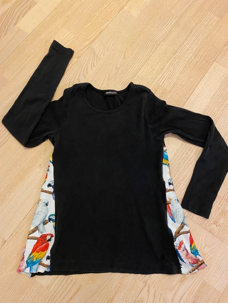 Musta paita, jota on levennetty värikkäällä kankaalla sivuista